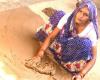 Lady polishing the floor using clay in Darbat Pur